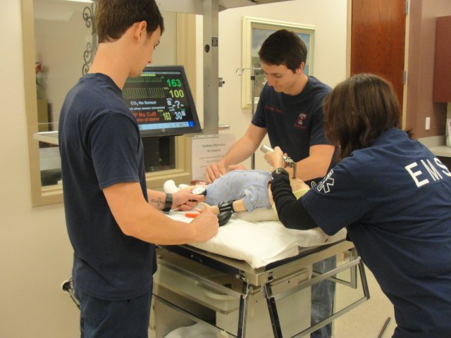 EMS Students checking vitals on infant simulator