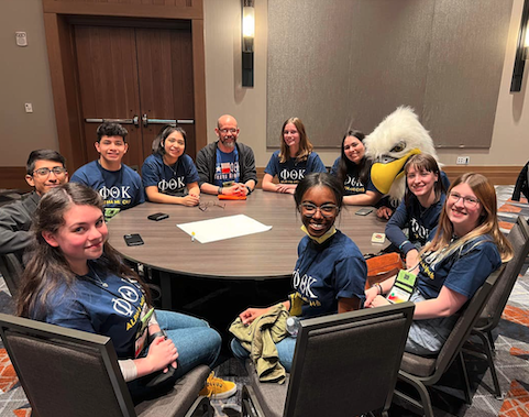 students seated around table at conference.