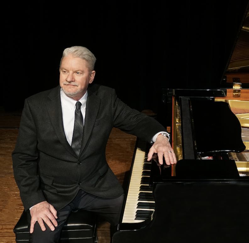 dr. clinton sitting at piano