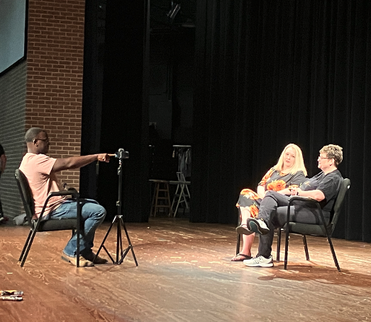 student interviewing people on Whatley stage