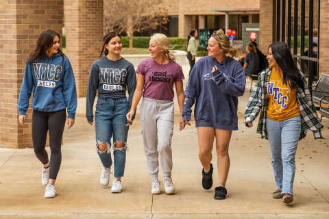 5 students walking across plaza