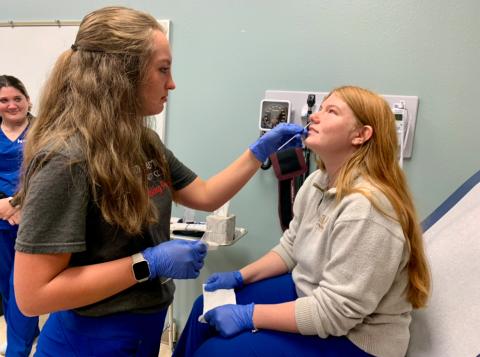 Medical Assistant student administering test on another student