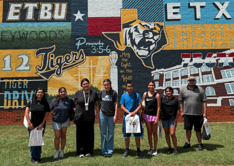 students in front of colorful mural