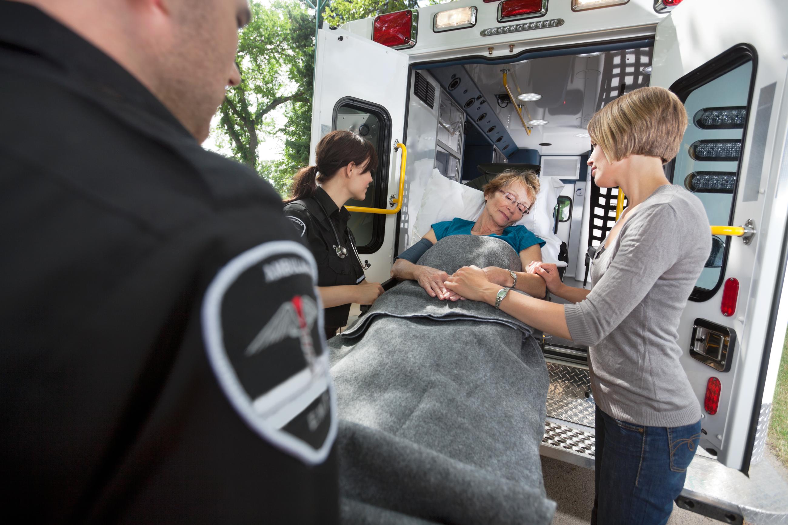 EMS loading patient on gurney into ambulance