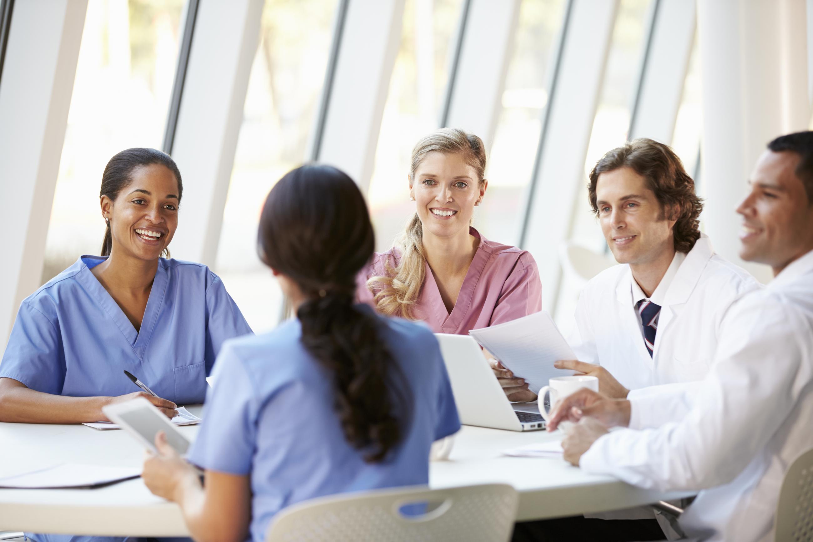 Doctors at conference table having discussion.