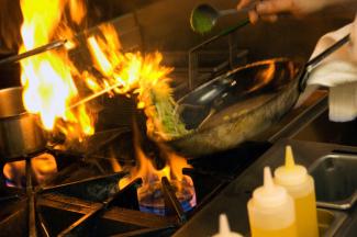 Culinary chef cooking with open flame
