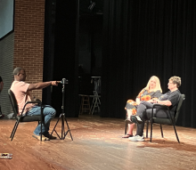 student interviewing people on Whatley stage