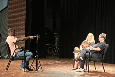 student interviewing people on Whatley stage