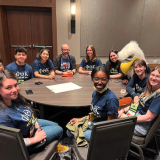 students seated around table at conference. 