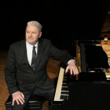 dr. clinton sitting at piano